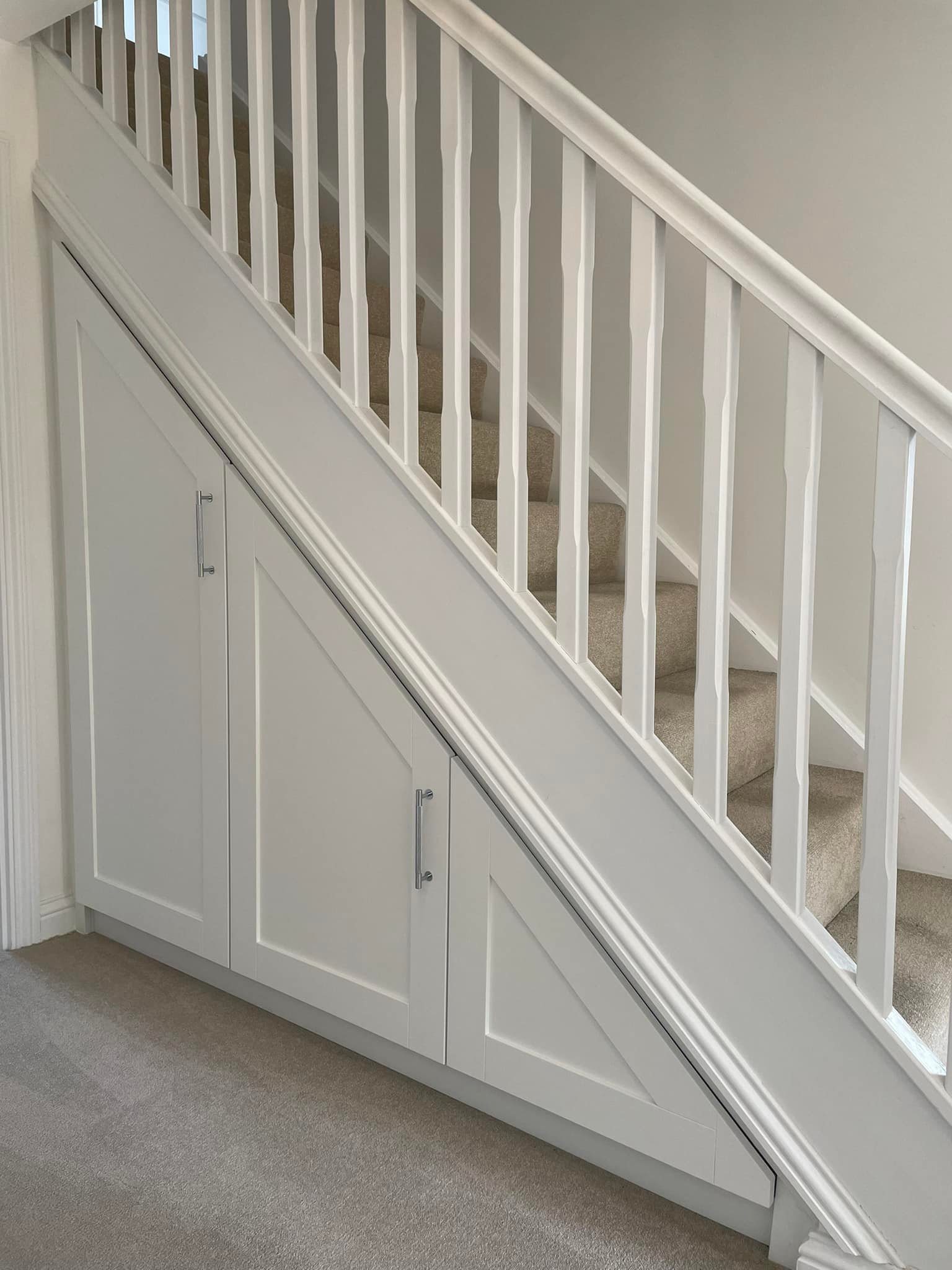 white under-stairs cupboards built by Jamie's Interiors
